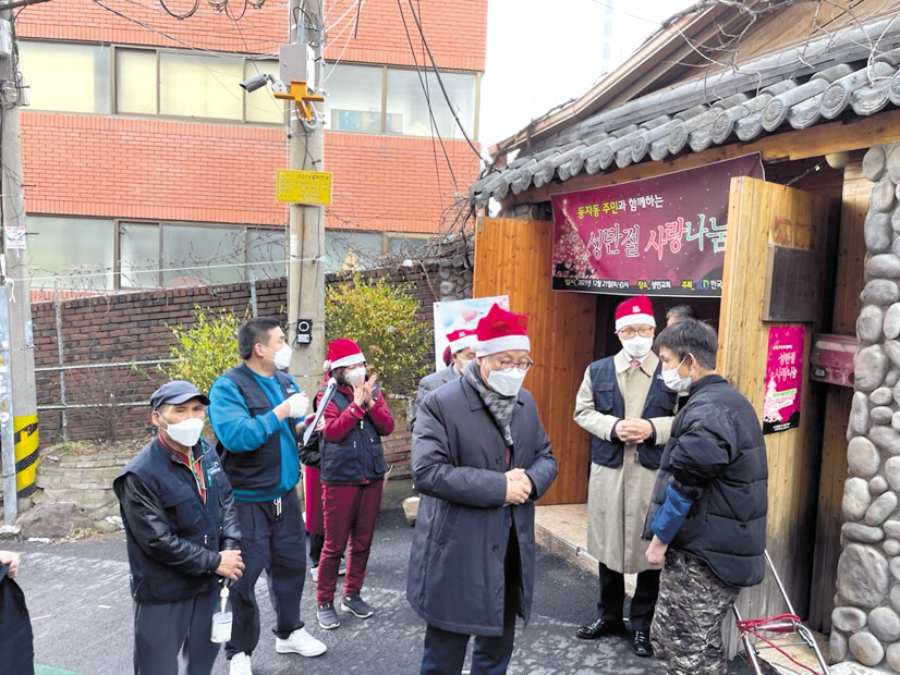 지난 21일 오후 서울 용산구 동자동의 한 거리에서 한국교회봉사단 소속 자원봉사자들이 주민들을 위한 나눔 행사를 진행하고 있다. [한국교회봉사단 제공]