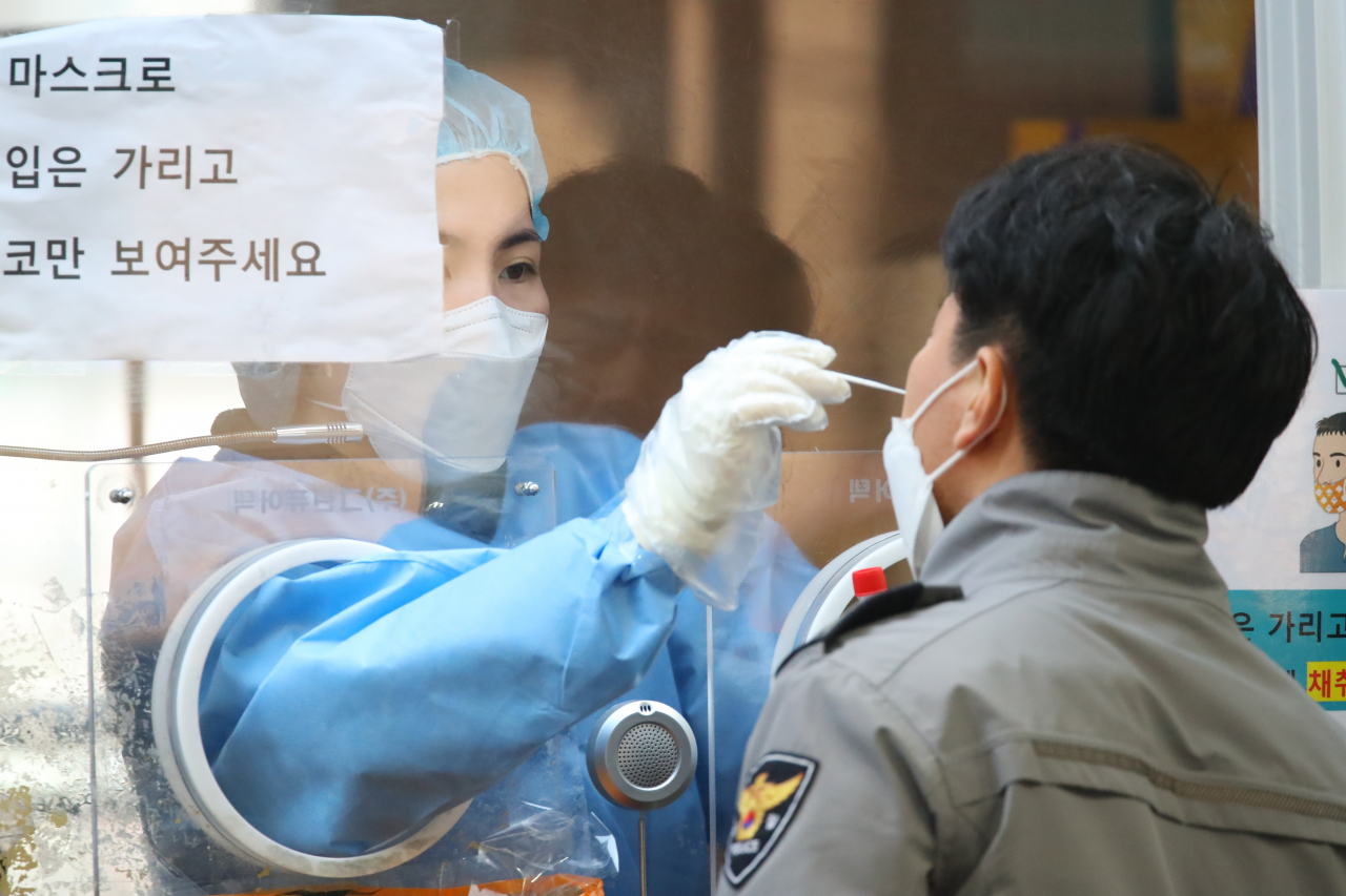 21일 오전 서울역 광장에 마련된 코로나19 임시선별검사소를 찾은 경찰이 코로나 검사를 받고 있다. [연합]