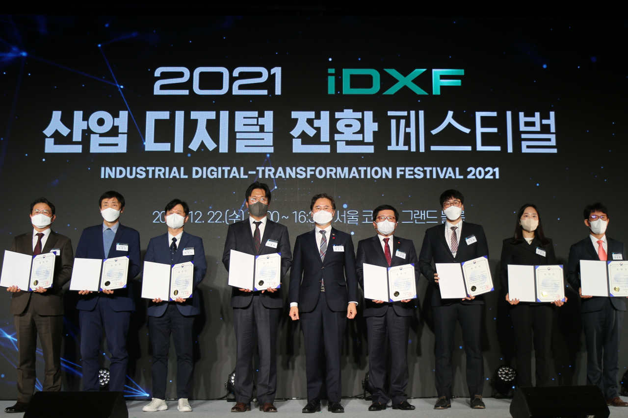 지난 22일 서울 강남구 코엑스에서 열린 2021년도 산업지능화대상 시상식에서 SK인천석유화학 이규호 SHE·Tech실장(오른쪽에서 네번째) 등 수상자들이 박진규 산업통상자원부 차관(가운데)과 기념사진을 촬영하고 있다. [SK인천석유화학 제공]