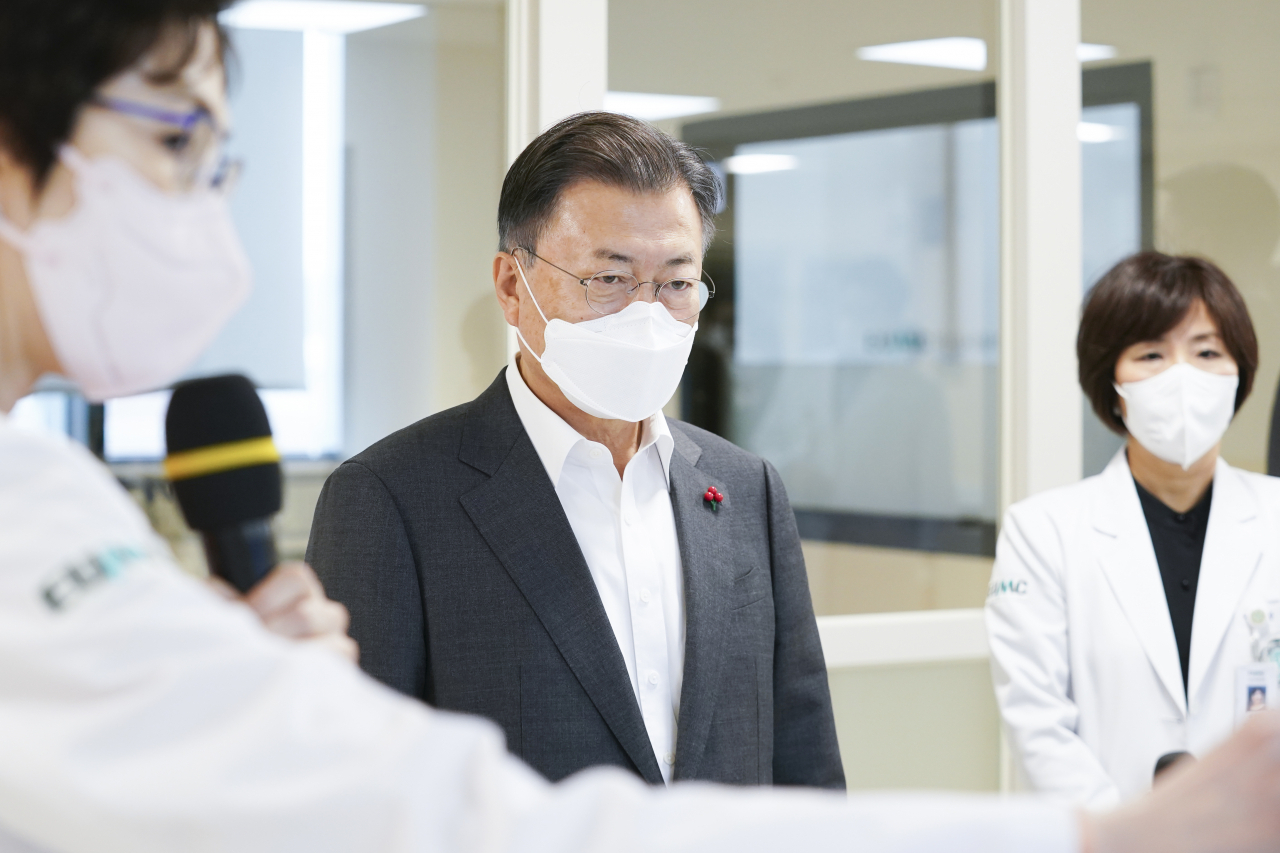 문재인 대통령이 24일 서울 강서구 마곡동 이화여자대학교 의과대학 부속 서울병원을 방문, 이선영 이대서울병원 전략기획본부장으로부터 병상확충 관련 브리핑을 받고 있다. [연합]