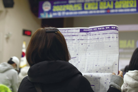 지난 17일 오후 서울 성동구청에서 열린 2022학년도 대입 정시 설명회에 참석한 학무보가 자료를 보며 설명을 듣고 있다. [연합]