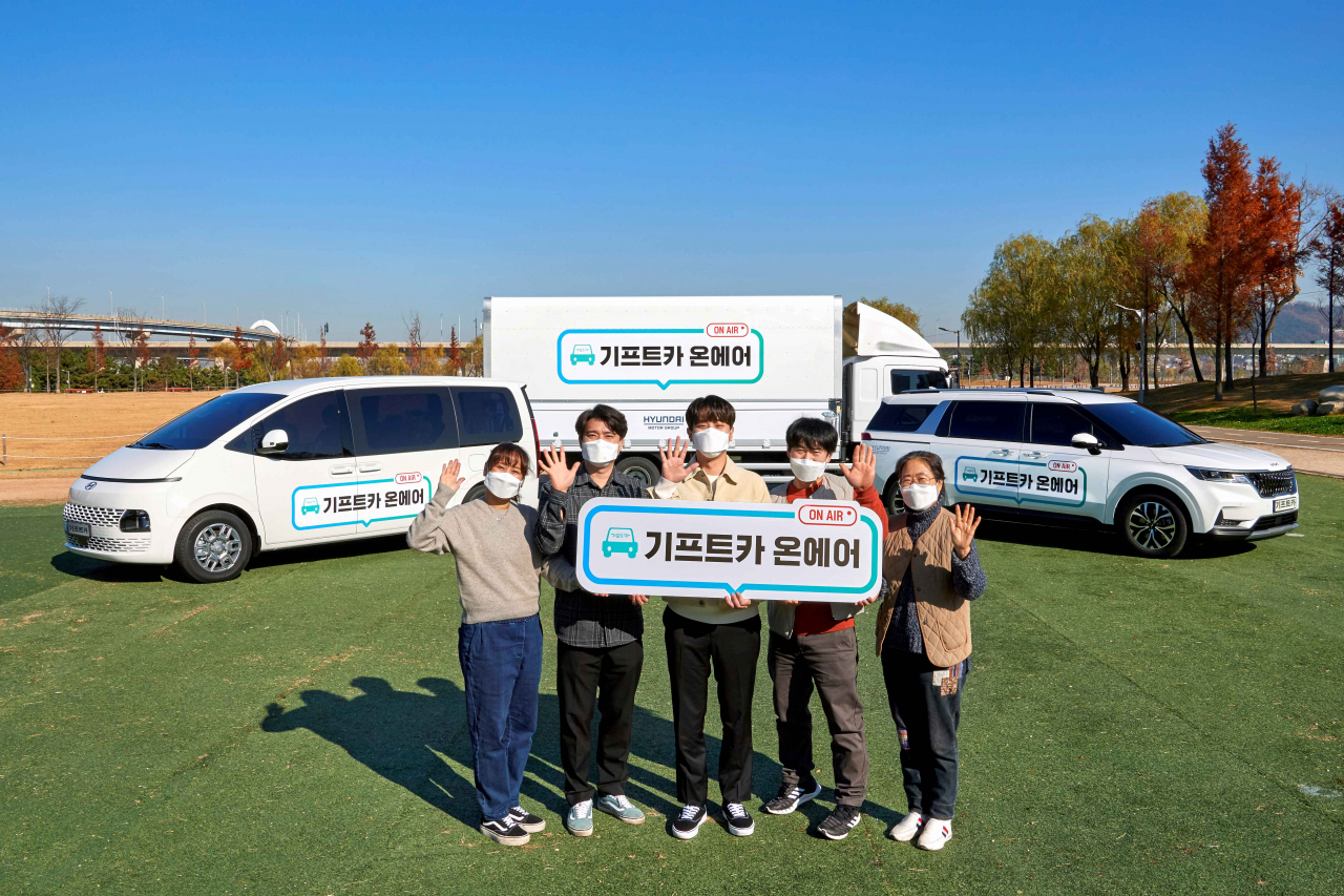 ‘기프트카 온에어’ 캠페인 차량과 온라인 영상에 출연한 배우 박정민(가운데)씨가 소상공인들을 응원하며 사진을 촬영하고 있다. [현대차그룹 제공]