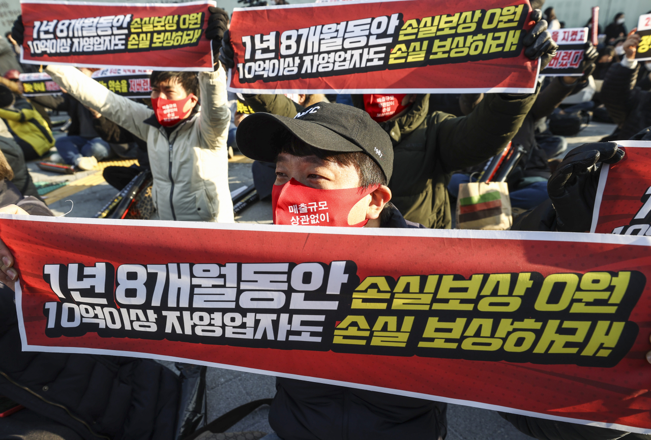 22일 오후 서울 광화문시민열린마당에서 열린 '코로나19 대응 전국자영업자비상대책위원회(자영업비대위) 정부 방역 대책 반대 총궐기 대회'에서 참석자들이 구호를 외치고 있다. [연합]