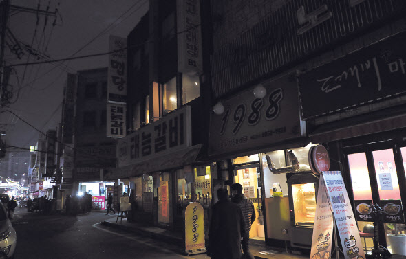 지난 28일 저녁 서울 강북구 수유리먹자골목 상인들이 신종 코로나바이러스 감염증(코로나19) 방역 정책에 항의하는 의미로 간판의 불을 끄고 영업하고 있다. 같은 날 한국외식업중앙회 등 소상공인 단체로 구성된 코로나피해자영업총연합(코자총)은 정부의 코로나19 방역 정책에 반발해 소등 시위를 벌였다. [연합]