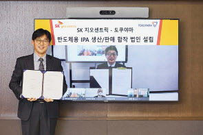최안섭 SK지오센트릭 전략본부장(왼쪽)과 노무라 히로시 도쿠야마 전자재료부문장이 합작법인 설립 계약서를 들고 기념사진을 촬영하고 있다. [SK이노베이션 제공]