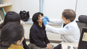 임광열 동아대병원 교수가 가족들과 함께 타시 데마의 수술 부위를 점검하고 있다. [동아대병원 제공]