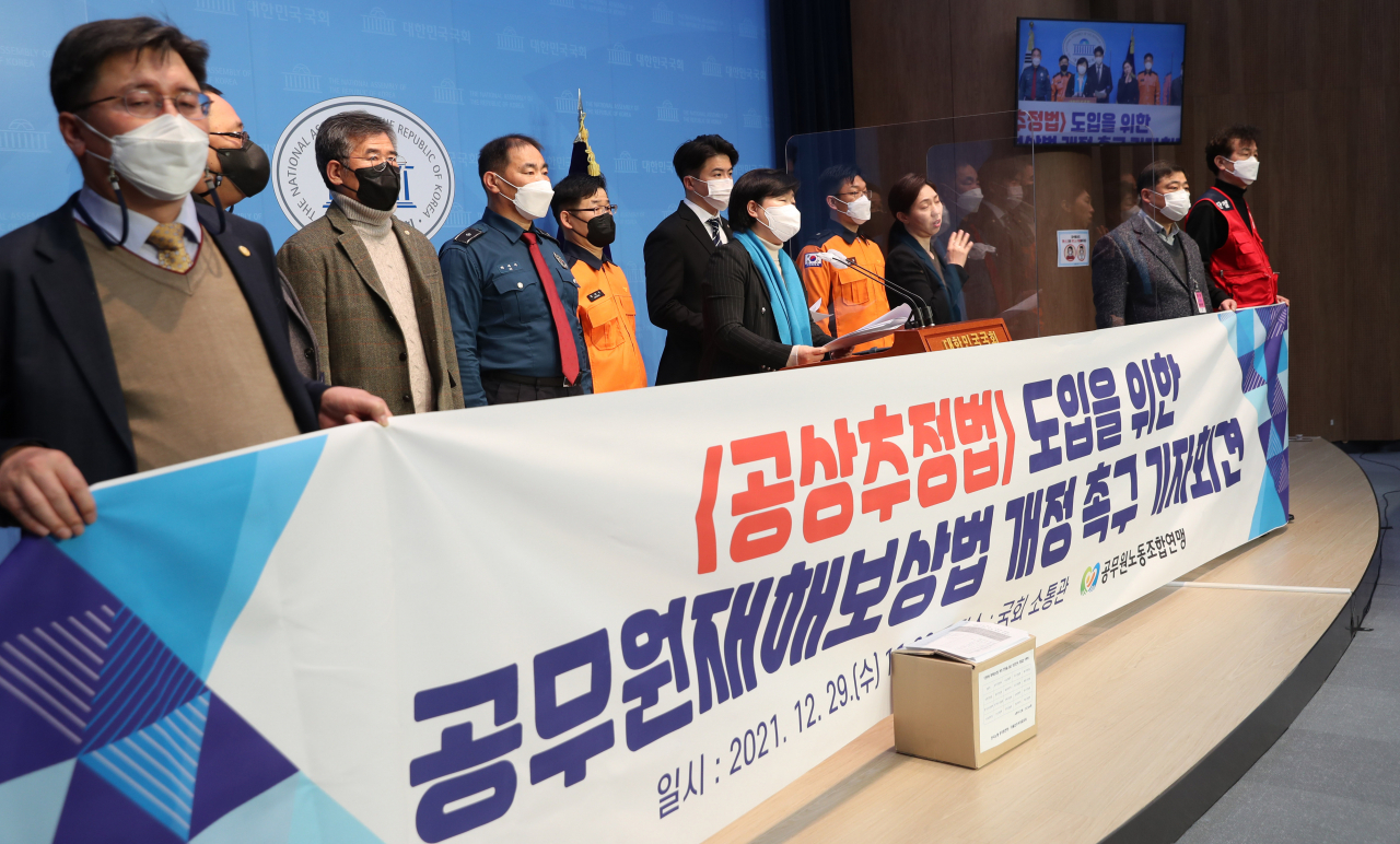 국회 행정안전위원회 서영교 위원장과 소방관 출신 오영환 의원을 비롯한 소방관, 경찰, 집배원 노동조합 관계자들이 29일 국회 소통관에서 공무수행 중 재해를 입은 공무원들에게 재해 인과관계 증명이나 입증 책임을 지도록 하는 불리한 조항이 담긴 현행 법규의 문제점을 지적하며 '공상추정법 도입을 위한 공무원재해보상법 개정 촉구 기자회견을 하고 있다. [연합]