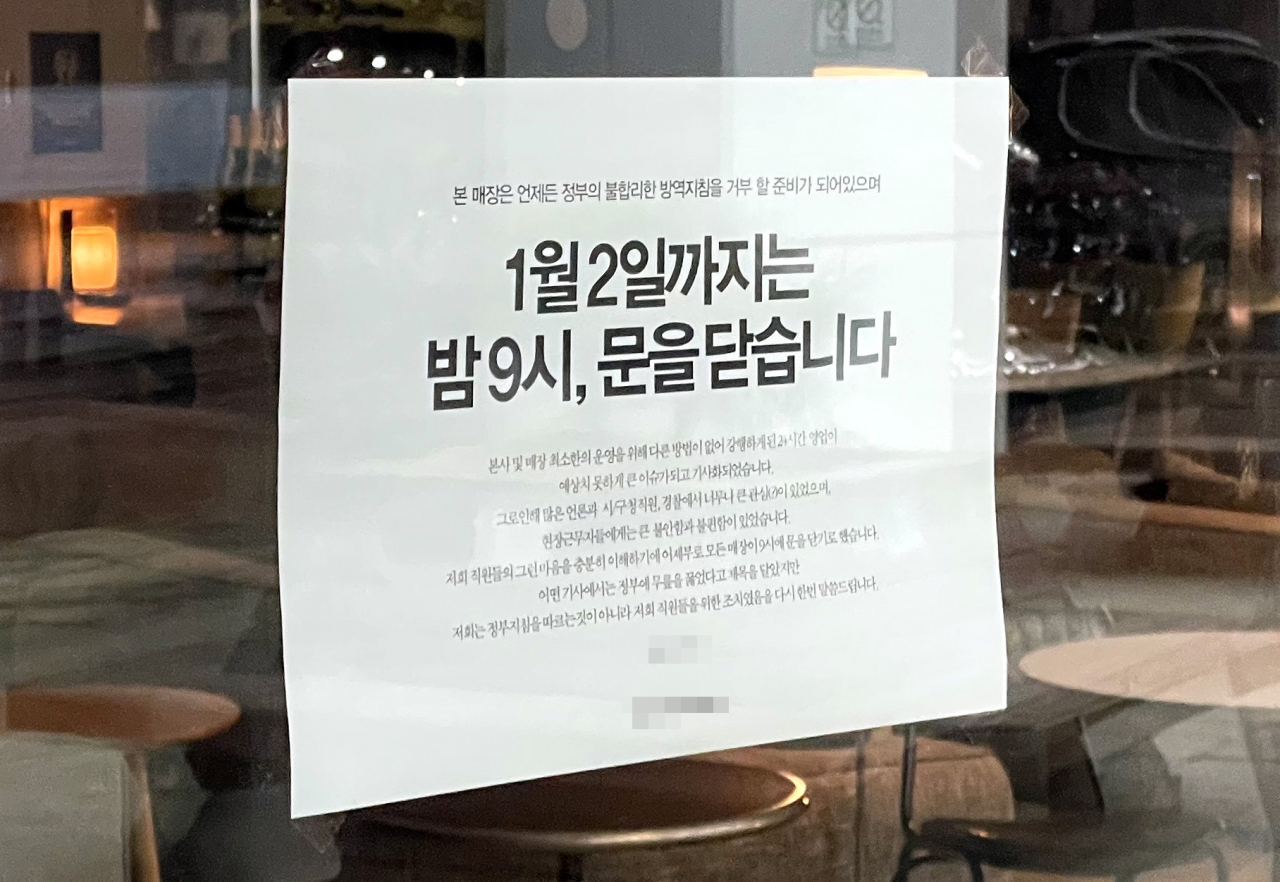 경찰이 영업시간 제한에 반발하며 24시간 영업을 강행했다가 고발된 인천의 대형 카페 본점과 직영점을 압수수색한 가운데 29일 오후 해당 카페 직영점인 인천시 연수구 모 카페 출입문에 다음 달 2일까지 오후 9시까지만 운영한다는 내용의 안내문이 부착돼 있다. [연합]