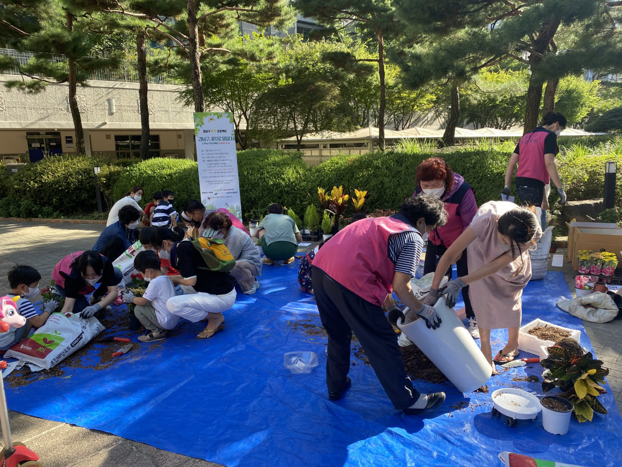 올해 서울시 에너지 자립마을로 선정된 서울 강남구 도곡렉슬 아파트 주민이 재활용품을 활용해 정원을 만드는 ‘업사이클링 가드닝’ 활동을 하고 있다. [서울시 제공]