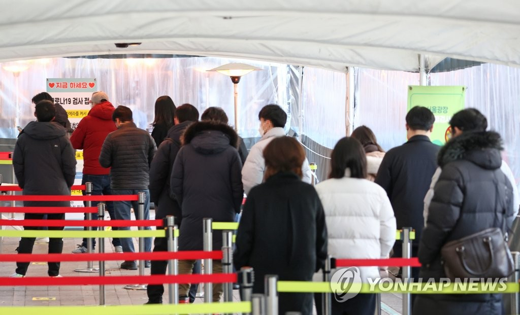 코로나19 신규 확진자 수가 5037명을 기록한 30일 오전 서울시청 앞 서울광장 코로나19 선별진료소를 찾은 시민들이 검사 순서를 기다리고 있다. [연합]