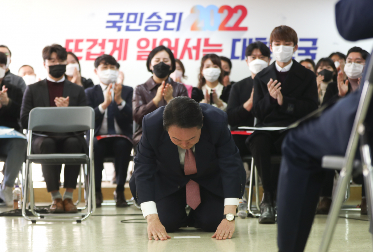 국민의힘 윤석열 대선 후보가 1일 오후 서울 여의도 대하빌딩에서 열린 선대위 신년인사회에서 구두를 벗고 국민들에게 큰절을 하고 있다. [연합]
