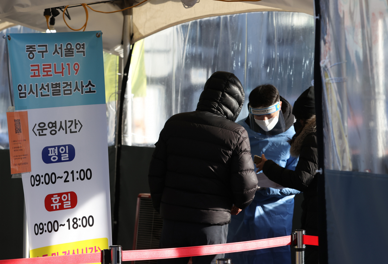 새해첫날인 1일 오전 서울 중구 서울역 광장에 마련된 코로나19 임시선별검사소에서 시민이 검사를 받기 위해 안내를 받고 있다. [연합]