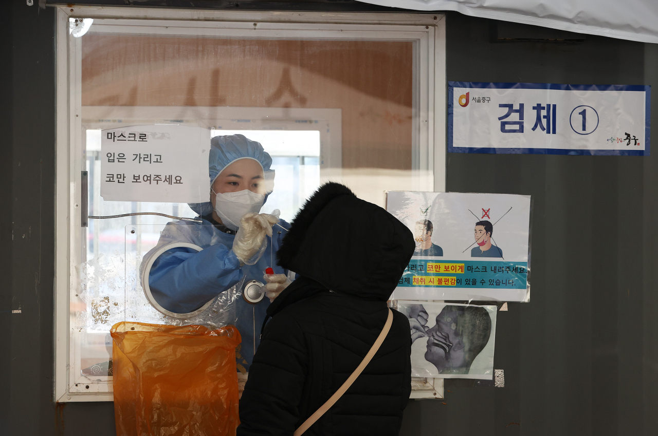 2022년 임인년(壬寅年) 첫날인 1일 오전 서울 중구 서울역 광장에 마련된 코로나19 임시선별검사소에서 의료진이 검체를 채취하고 있다. 중앙방역대책본부(방대본)는 이날 0시 기준으로 코로나19 신규 확진자가 4416명 늘어 누적 확진자 수가 63만5253명이라고 밝혔다. 연합뉴스