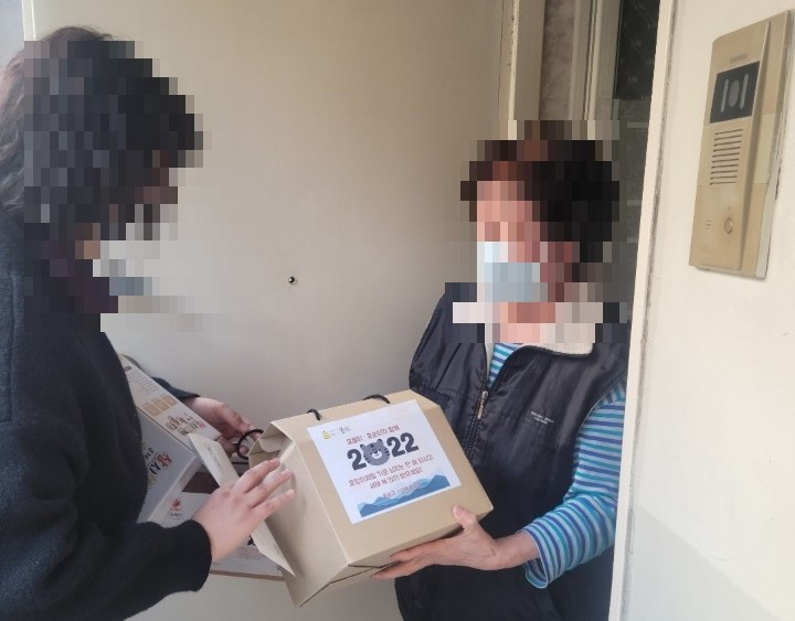 서울의 한 노인종합복지관 관계자가 지역 어르신에게 선물 꾸러미를 전달하고 있다. [종로구청 제공]