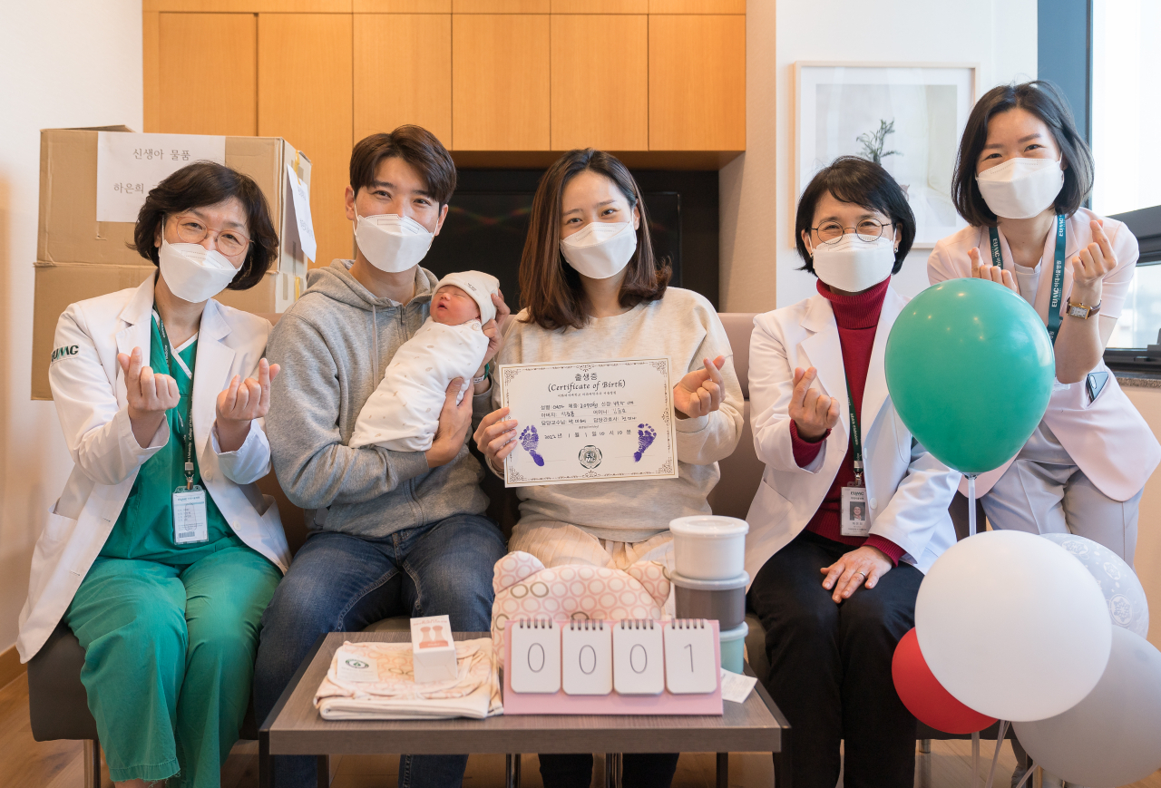 사진 왼쪽부터 박미혜 이대서울병원 모아센터장, 박준용(아기를 안고 있는) ‧김동효 부부, 하은희 이화여대 의과대학 학장, 신정란 모아병동 파트장. 이대서울병원 제공