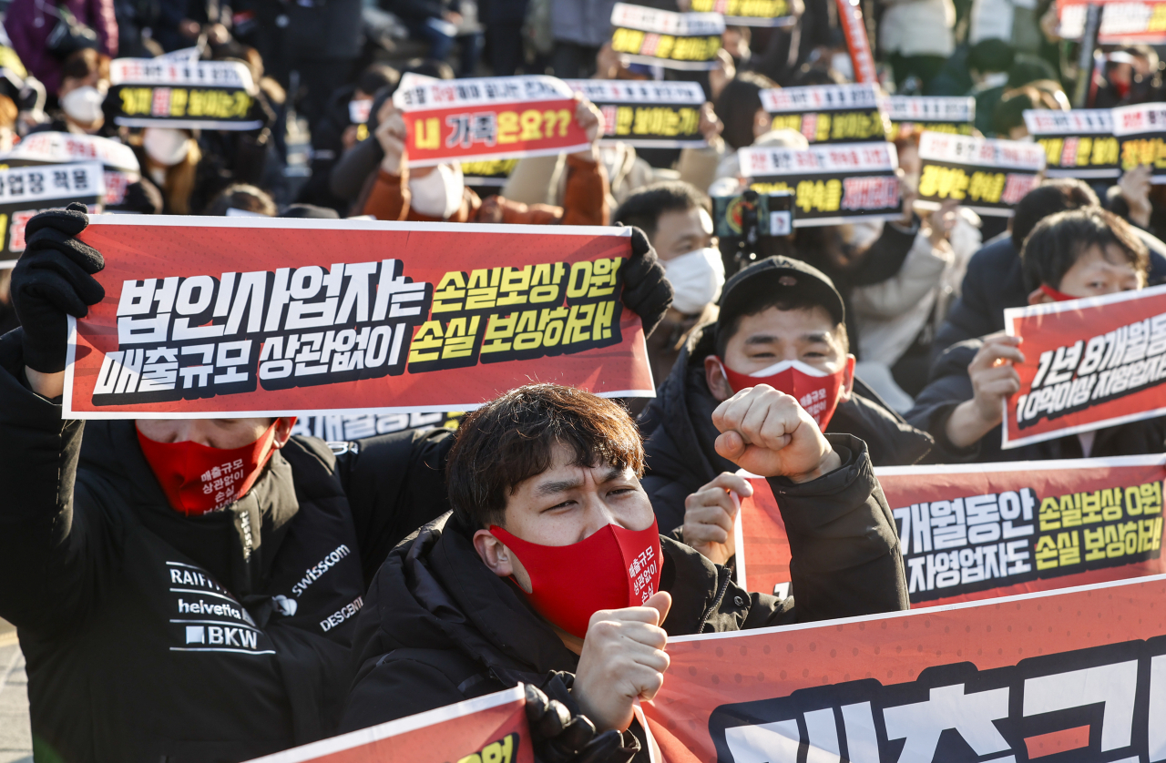 지난달 22일 오후 서울 광화문시민열린마당에서 열린 ‘코로나19 대응 전국자영업자비상대책위원회(자대위) 정부 방역 대책 반대 총궐기 대회’에서 참석자들이 구호를 외치고 있다. [연합]
