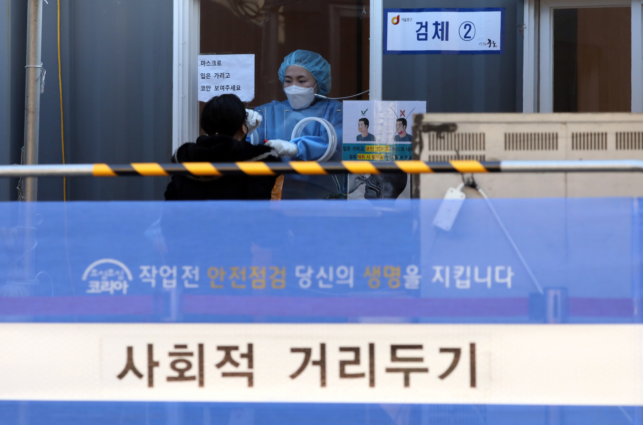 서울역에 마련된 임시선별진료소에서 한 의료진이 시민에게 PCR 검사를 하고 있다. [연합]