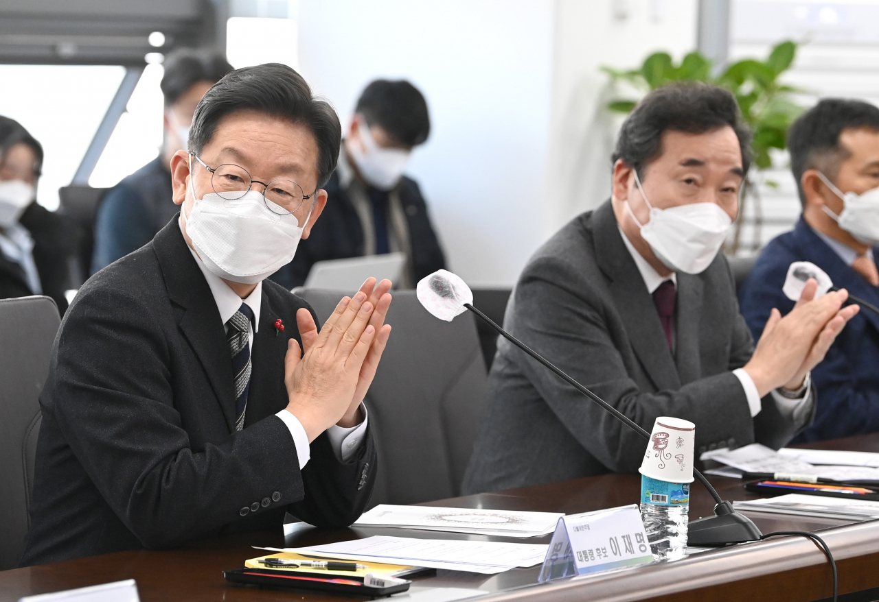 더불어민주당 이재명 대선후보(왼쪽)와 이낙연 국가비전·국민통합위원회 공동위원장이 지난달 29일 서울 광진구 보건복지행정타운의 한국사회보장정보원을 방문, 참석자 소개를 들으며 박수 치고 있다. [국회사진기자단]