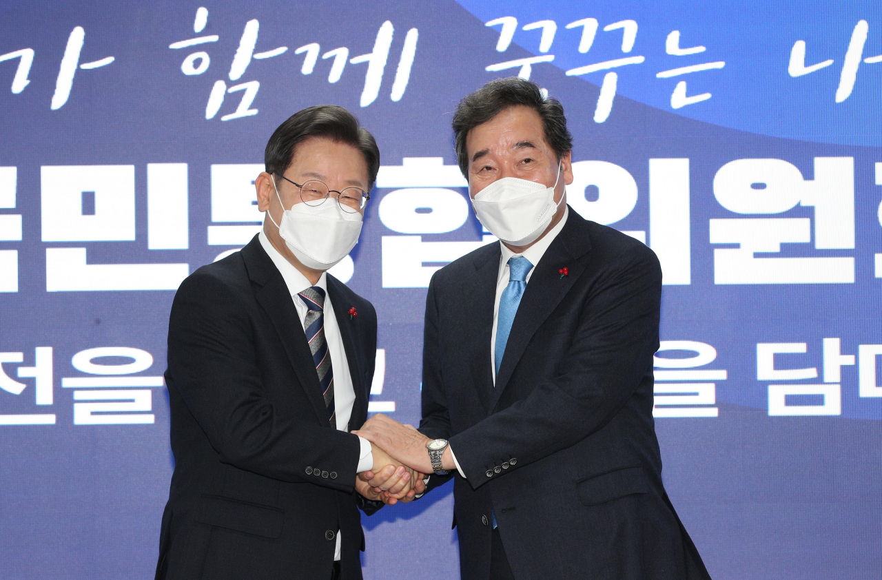 더불어민주당 이재명 대선후보(왼쪽)와 이낙연 공동위원장이 지난해 12월 27일 오전 서울 여의도 당사에서 열린 국가비전·국민통합위원회 출범식에서 손을 잡고 있다. [이상섭 기자]