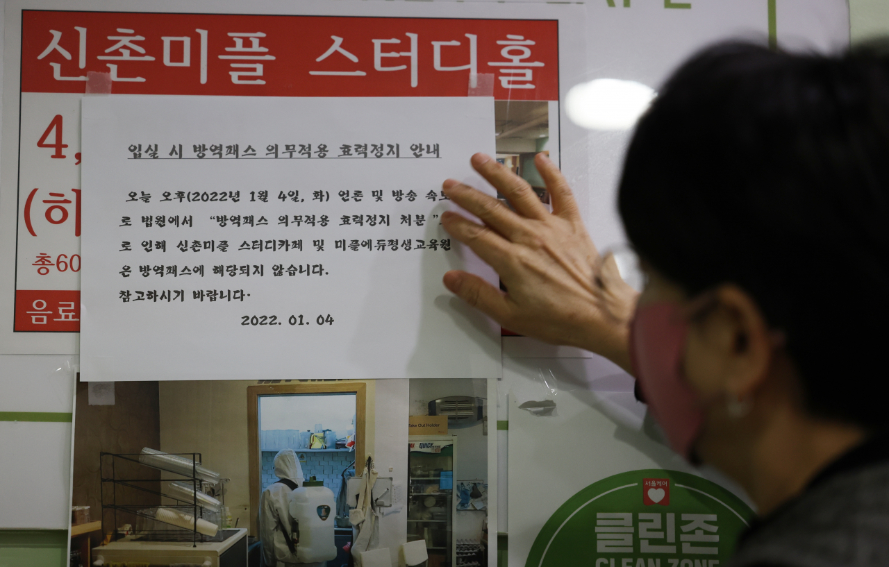 지난 4일 오후 서울 서대문구 신촌 한 스터디카페에서 이 곳 관계자가 ‘방역패스 적용 중단’ 안내문을 붙이고 있다. [연합]