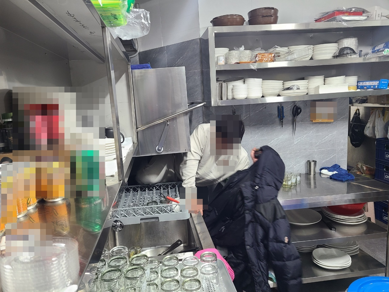 지난 4일 서울 강남구 A유흥주점에서 술을 마시던 사람들 중 보이스피싱(투자사기·메신저 피싱) 등으로 2년간 도주 중에 있던 지명수배자가 단속 과정에서 한 주방 식기세척기 밑에 숨어 있다가, 경찰에 발견되고 있는 모습. [수서경찰서 제공]