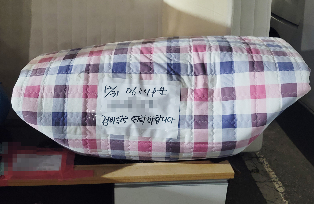 탈북민 A씨가 지난해 마지막 날 분리수거장에 내놓은 이불류. 배출 서류를 붙여놓지 않아 '경비실로 연락 바란다'는 안내문이 붙어있다. [연합]