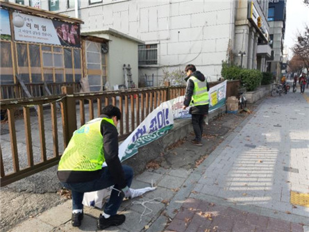 은평구는 ‘2022 불법광고물 수거보상제’를 운영한다고 6일 밝혔다. 사진은 은평구 불법광고물 수거보상원이 현수막을 정비하고 있는 모습. [은평구 제공]