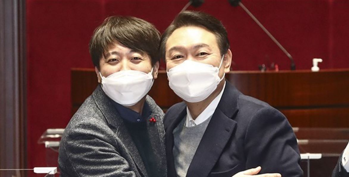 Yoon Suk-yeol (right), the presidential candidate of the People Power Party, and PPP chief Lee Jun-seok pose for a photo after the party meeting at the National Assembly in Seoul on Jan. 6, 2022. (Yonhap)