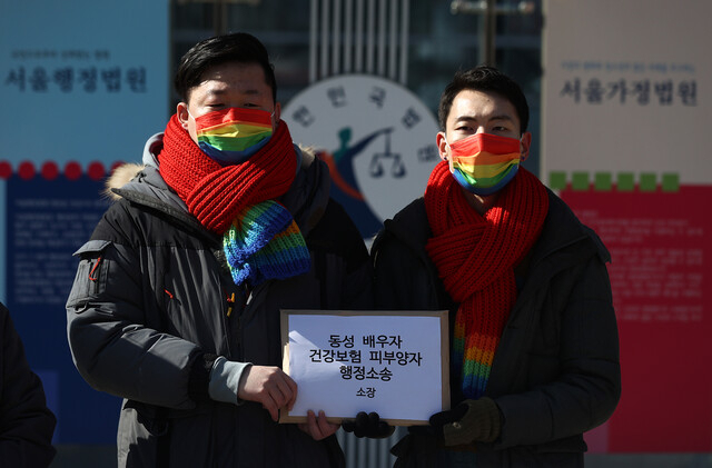 2021년 2월 18일 오전 서초구 서울행정법원 앞에서 열린 '동성 배우자 건강보험 피부양자 소송 기자회견'에서 소송 당사자 김용민-소성욱 부부가 소장을 들어보이고 있다. [연합]