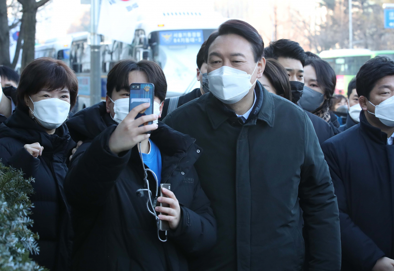 국민의힘 윤석열 대선 후보가 7일 오전 서울 지하철 9호선을 타고 서울 여의도 국회의사당역에서 출근하며 지지자와 셀카를 찍고 있다. 연합뉴스