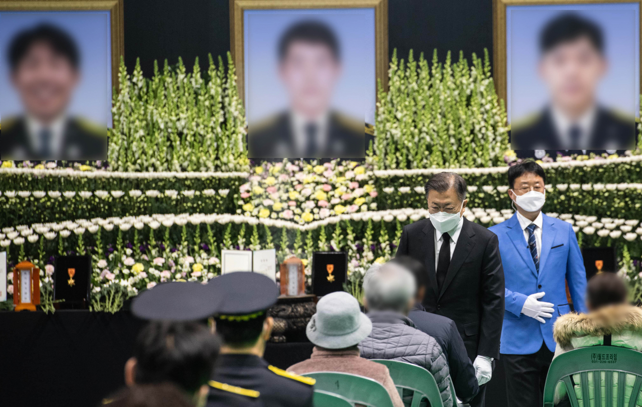 문재인 대통령이 8일 오전 경기도 평택시 이충문화체육센터에서 엄수된 평택 신축 공사장 화재 순직 소방공무원 합동 영결식에서 헌화 및 분향을 마친 후 유족을 위로하고 있다. [연합]