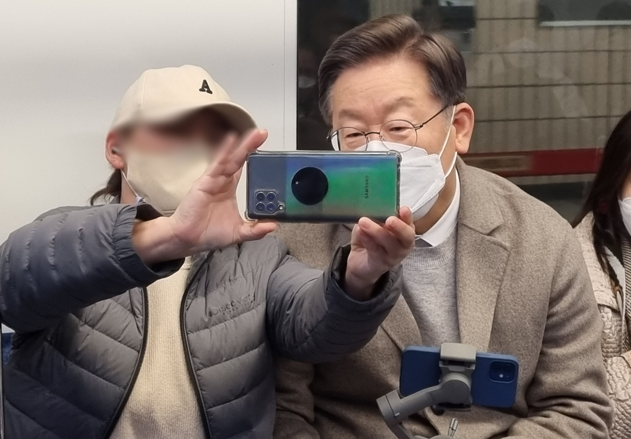 더불어민주당 이재명 대선 후보가 지난 7일 오후 '매타버스 시즌2, 걸어서 민심속으로' 일환으로 지하철을 타고 숙대입구역에서 총신대 역까지 이동하며 시민들과 셀카를 찍고 있다. [연합]