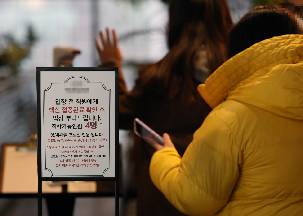 서울의 한 식당 앞에 백신 접종완료 확인 관련 안내문이 붙어 있다. 1월3일부터 방역패스(접종증명·음성확인제)에도 6개월 유효기간이 적용되고 있다. 이에 따라 지난해 7월 6일이나 그보다 전에 기본접종을 마쳐 이날로 180일이 지났지만, 아직 추가접종을 하지 않았다면 영화관 등 방역패스 적용 시설에 입장할 수 없게 된다. [연합]