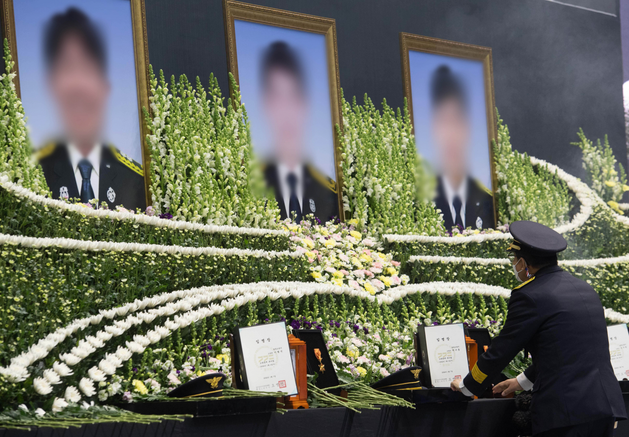 지난 8일 경기 평택시 이충문화체육센터에서 엄수된 평택 신축 공사장 화재 순직 소방공무원 합동 영결식에서 동료 소방관이 헌화를 마치고 슬픔에 잠겨 있다. [연합]