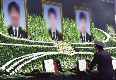 지난 8일 경기도 평택시 이충문화체육센터에서 엄수된 평택 신축 공사장 화재 순직 소방공무원 합동 영결식에서 동료 소방관이 헌화하고 있다. [연합]