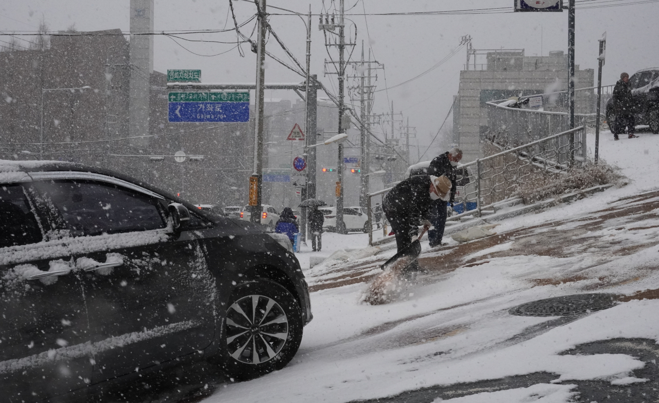 서울시는 10일 저녁 수도권에 눈이 내릴 것으로 예보됨에 따라 오후 3시부터 ‘제설1단계’를 발령하고 비상근무체제에 돌입했다. 사진은 올겨울 첫 대설주의보가 내려진 지난달 18일 서울 서대문구 연희동 부근 언덕길의 제설작업 장면. [연합]