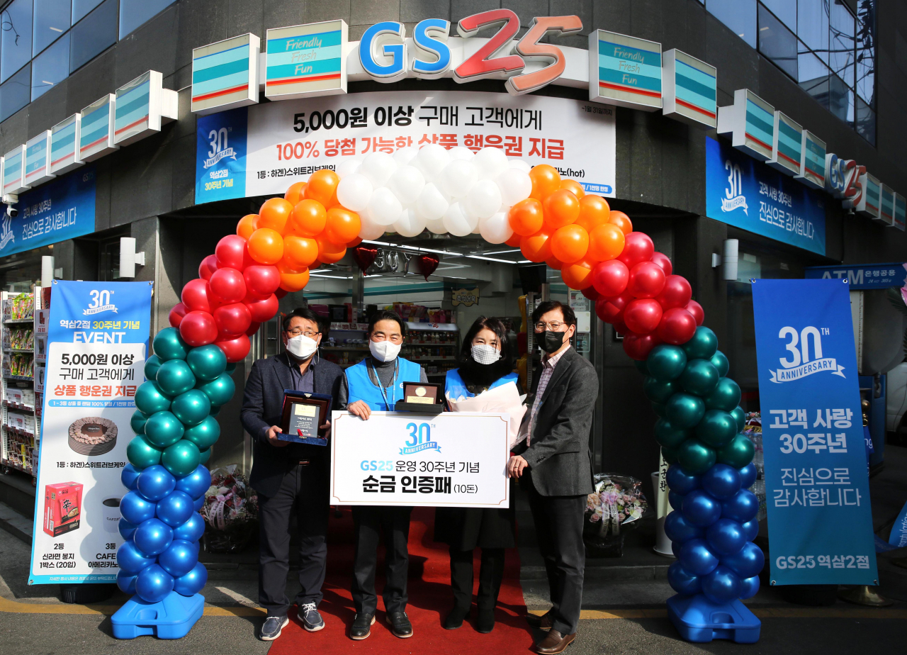 이달 10일 진행한 GS25역삼2점 30주년 기념식에서 성인제 경영주(왼쪽에서 두 번째), 최영미 배우자(오른쪽에서 두 번째), 오진석 GS리테일 플랫폼 BU장(오른쪽 끝), 정재형 GS25 사업부장(왼쪽 끝)이 기념 촬영을 하고 있다.[GS리테일 제공]