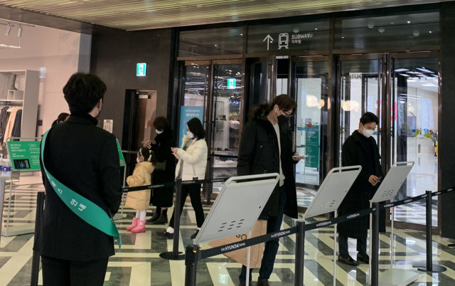 면적 3000㎡ 이상의 쇼핑몰, 마트, 백화점, 농수산물유통센터, 서점 등 대규모 상점 등에 대한 방역패스(접종증명·음성확인제) 적용이 시작된 10일 서울의 한 대형마트(위쪽 사진)와 백화점에서 직원들이 고객들에게 방역패스 안내를 하고 있다. 이정아 기자