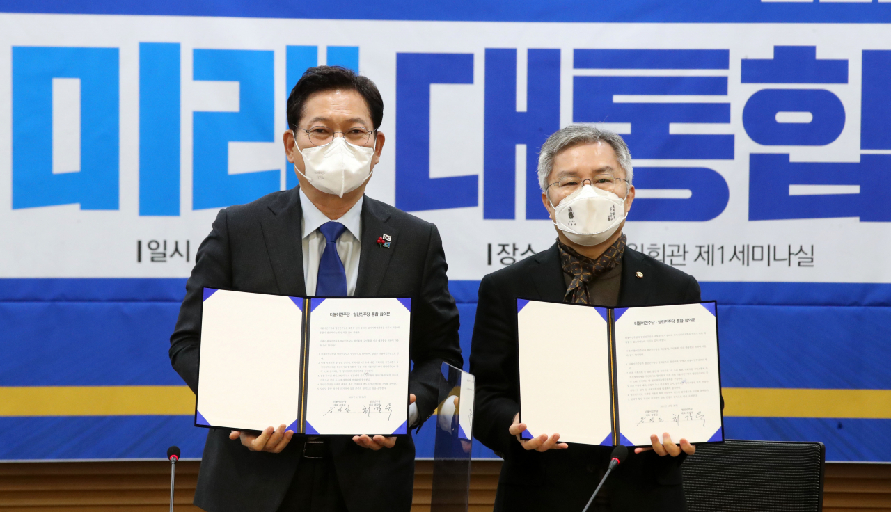 더불어민주당 송영길 대표(왼쪽)와 열린민주당 최강욱 대표가 지난달 26일 오전 국회 의원회관에서 양당 통합 합의문에 서명한 뒤 기념촬영을 하고 있다. [사진=이상섭 기자]