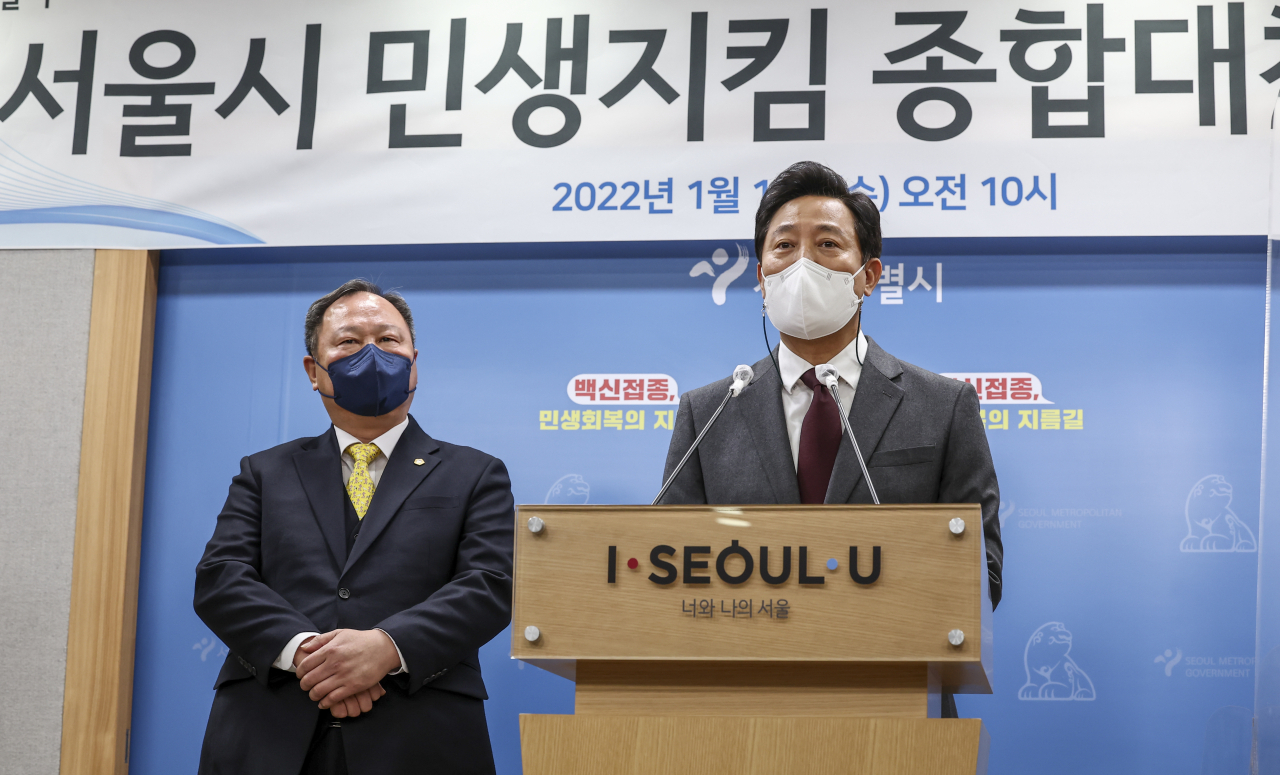 2022년 예산안 삭감을 두고 시의회와 연일 SNS를 통해 설전을 벌이고 있는 오세훈 서울시장이 이번엔 자신의 공약사업 ‘서울런’을 두고 시의회를 비판했다. 사진은 오세훈 서울시장이 12일 서울시청에서 열린 서울시 민생지킴 종합대책 발표에서 취재진 질문에 답하고 있는 모습. 왼쪽은 서울시의회 의장. [연합]