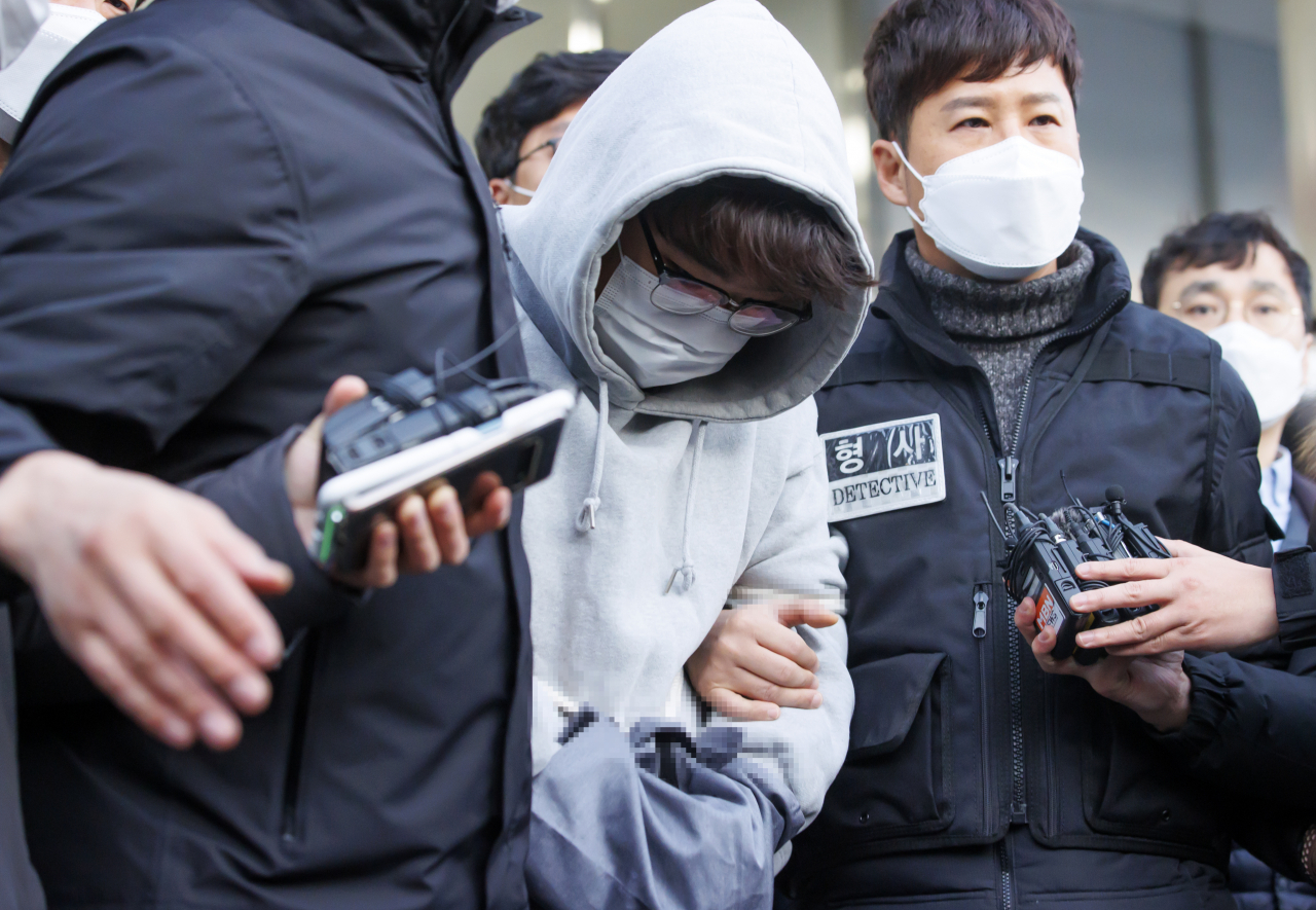 한때 교제했던 여성의 집을 찾아가 가족을 살해한 혐의를 받는 이석준이 지난해 12월 17일 오전 서울 송파경찰서에서 나와 검찰로 송치되고 있다. 이석준은 범행 전 구청 공무원이 유출한 개인정보를 흥신소를 통해 구매한 것으로 알려졌다. [연합]