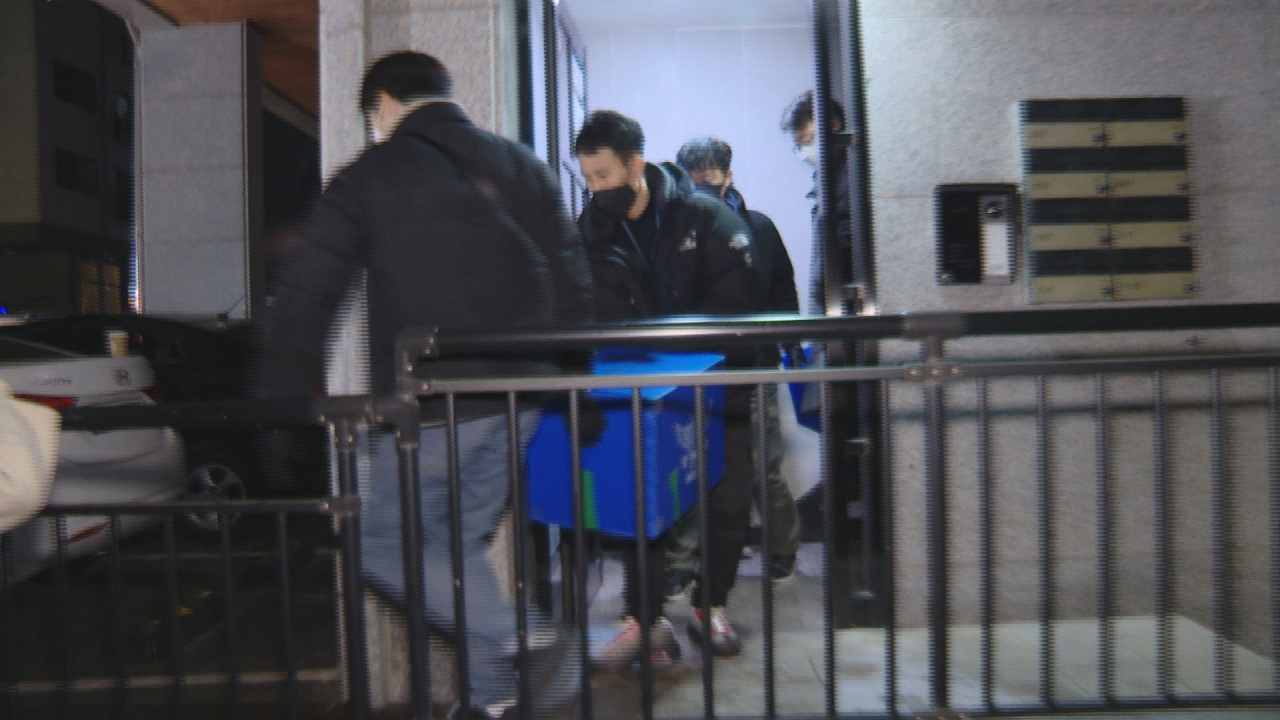 지난 10일 오후 오스템임플란트 회삿돈 2215억 원을 횡령한 직원 이모씨 가족의 경기 파주 주거지에서 경찰이 압수수색을 마친 후 압수품을 옮기고 있다. [연합]