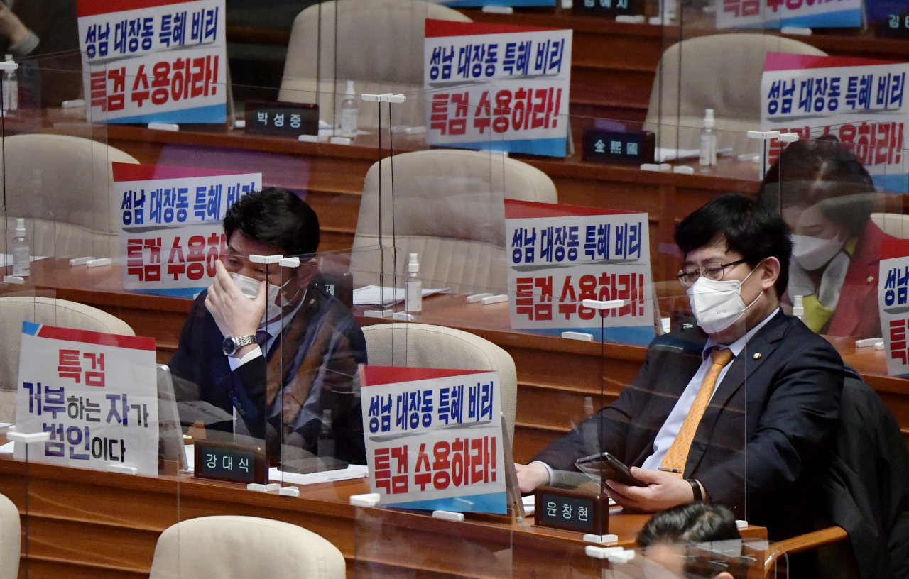 11일 오후 서울 여의도 국회에서 열린 새해 첫 본회의에서 국민의힘 의원들이 '대장동 특혜의혹' 특검수용을 촉구하는 피켓을 의원석에 놓고 회의에 참석하고 있다. [연합]