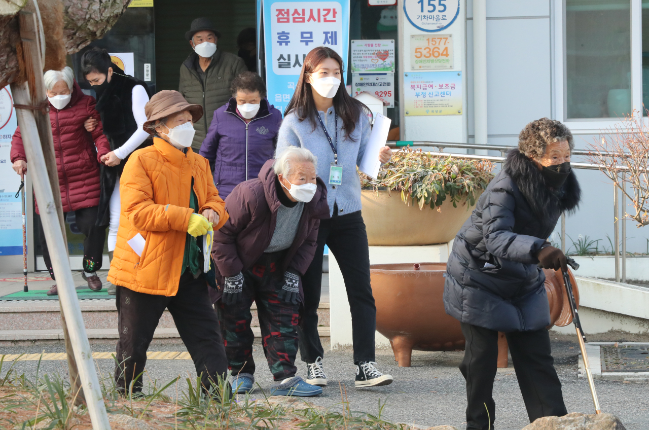 Civil servants guide the elderly seeking COVID-19 vaccination in South Jeolla Province, in this photo taken Dec. 24. 2021. (Yonhap)