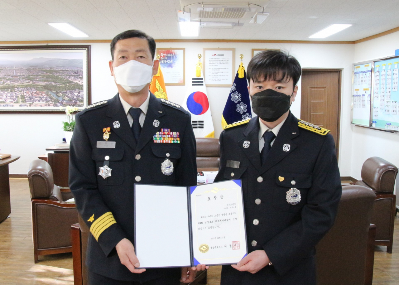 ‘하트세이버 왕’ 표창장과 배지를 받은 박동국(오른쪽) 소방관이 12일 한창완 경주소방서장과 기념 사진을 찍고 있다.[경주소방서 제공]