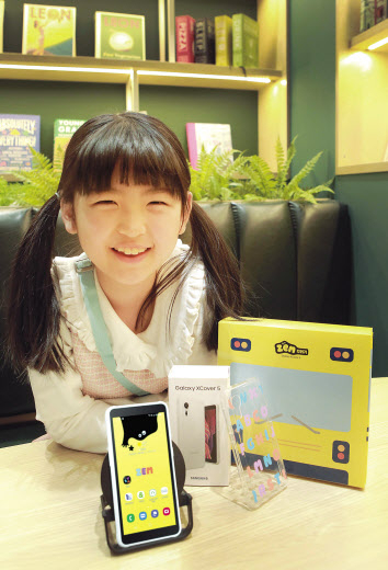 SK텔레콤 홍보모델이 SKT 키즈용 스마트폰 ‘ZEM 꾸러기 폰(SM-G525N_ZEM)’을 선보이고 있다. [SK텔레콤 제공]