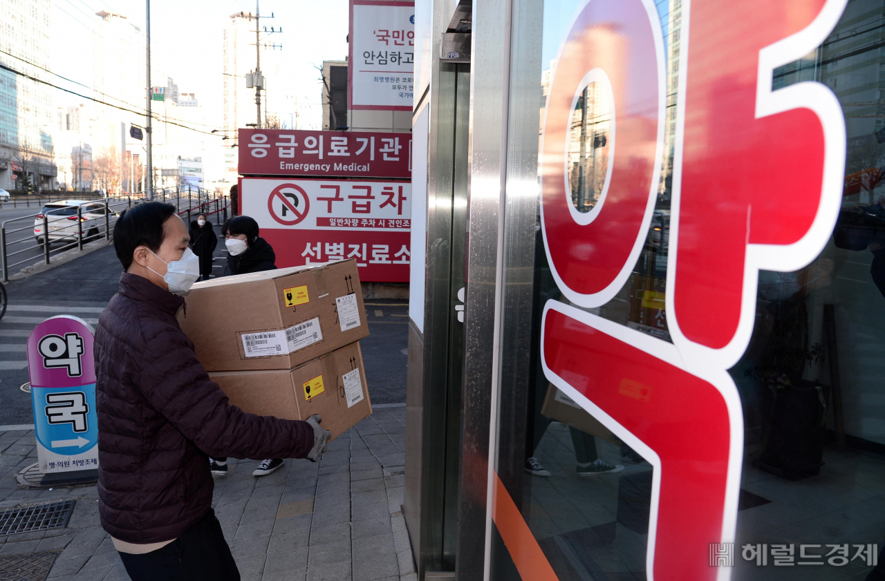 14일 오전 서울 금천구의 한 약국에서 약사와 유통업체 관계자가 먹는 코로나19 치료제인 '팍스로이드'를 살펴보고 있다. 코로나19에 확진돼 생활치료센터에 입소한 사람과 재택 치료를 받는 사람 등에게 처방한다. 전국 생활치료센터 91곳과 지정 약국 281곳을 통해 약을 공급할 예정이다. 박해묵 기자