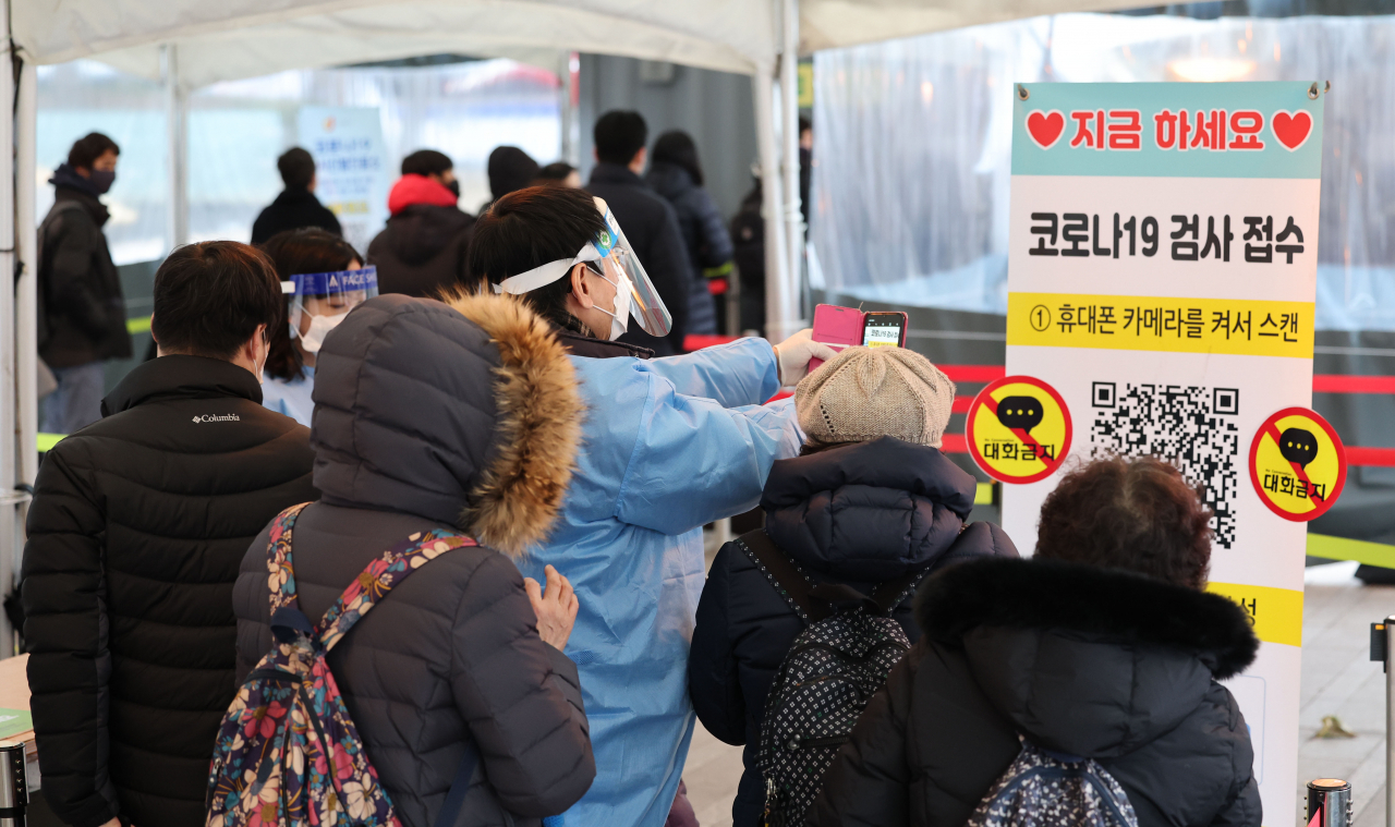 신종 코로나바이러스 감염증(코로나19) 신규 확진자 수가 4423명을 기록한 15일 오전 서울시청 앞 서울광장 코로나19 선별진료소에서 의료진이 QR코드 검사 접수에 어려움을 겪는 시민들을 대신해 접수를 하고 있다. [연합]