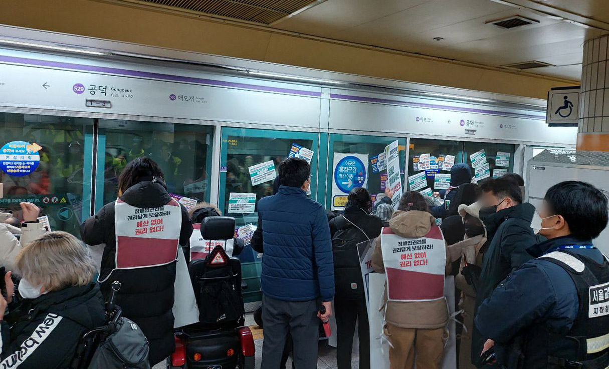 지난해 12월 31일 오후 서울 지하철 5호선 공덕역&rarr;방화역 구간에서 전국장애인차별철폐연대의 시위가 진행되고 있다. 이 시위로 열차 운행이 30여분 지연됐다. [연합]