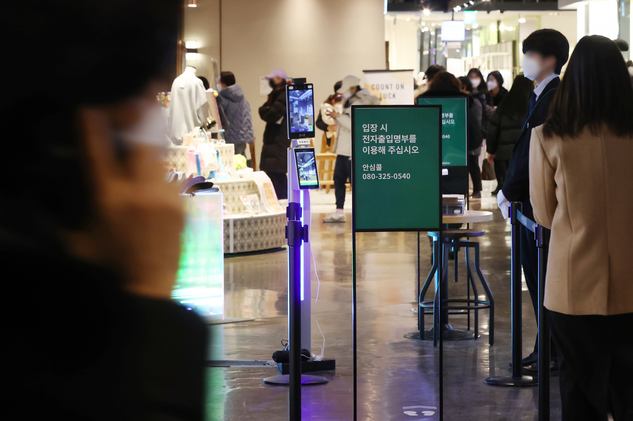 16일 서울의 한 백화점 입구에서 시민들이 QR코드 체크를 하고 있다. [연합]